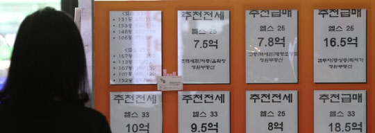 한 시민이 서울의 한 부동산공인중개업소에 걸린 아파트 급매물 시세를 살펴보고 있다.<연합뉴스>